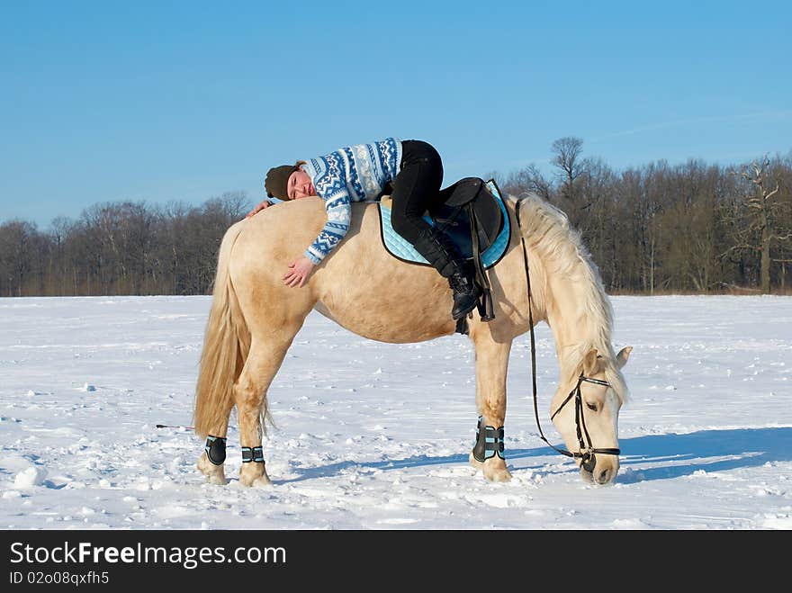 Young girl lying back to front on a horsback. Young girl lying back to front on a horsback