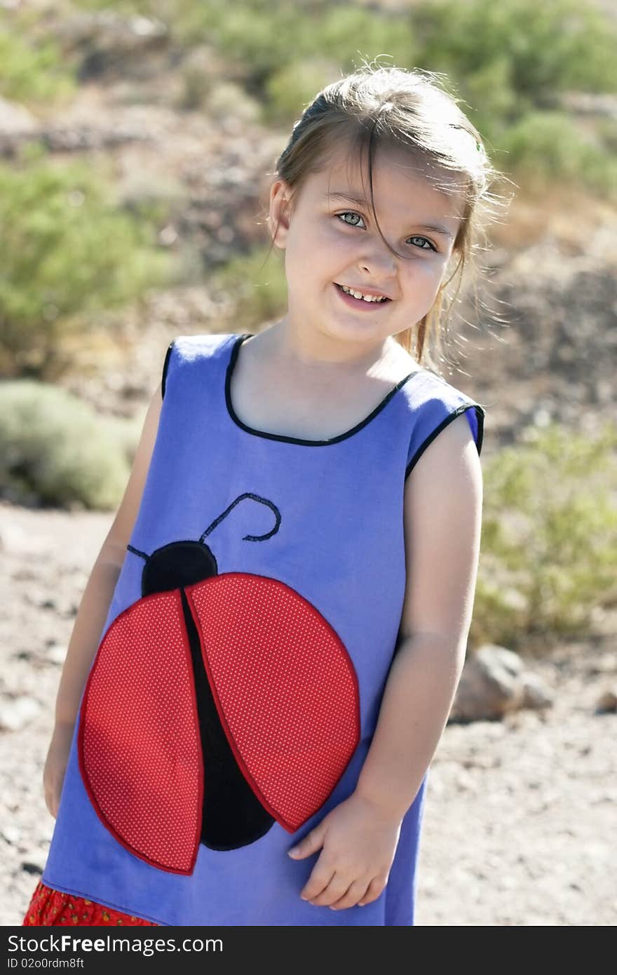 Portrait of a pretty young smiling girl on a windy day in the desert. Portrait of a pretty young smiling girl on a windy day in the desert.