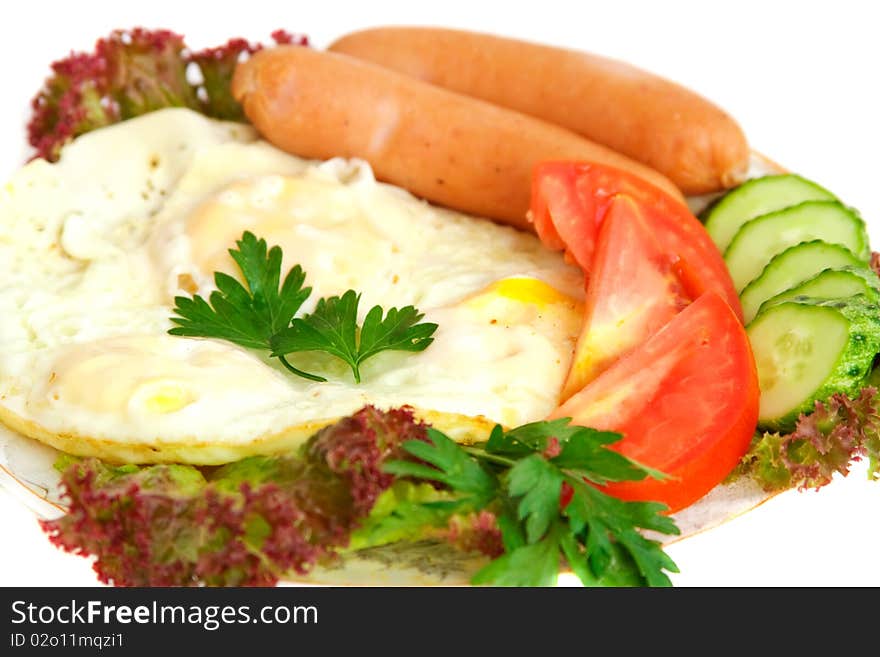 Breakfast of fried eggs, sausages, tomato, cucumber, lettuce