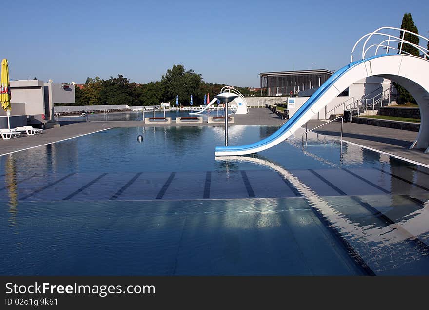 Dispeopled bath pool with white slide