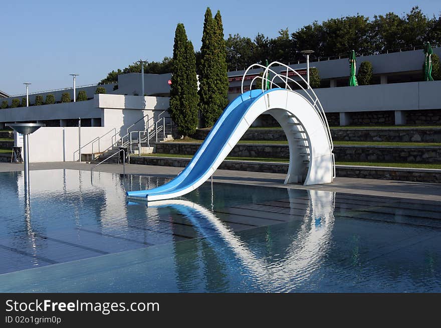 Dispeopled bath pool with white slide