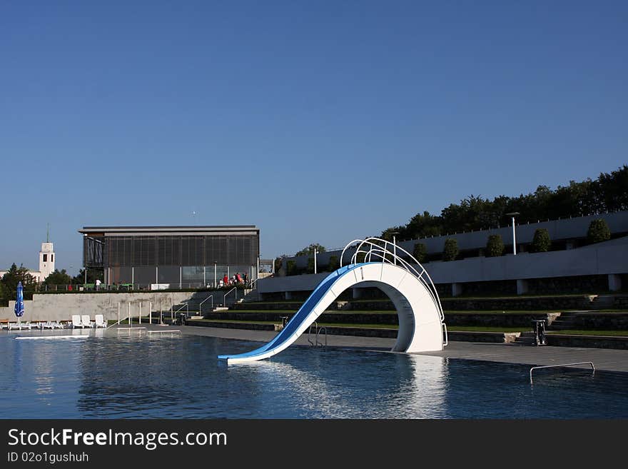 Dispeopled bath pool with white slide