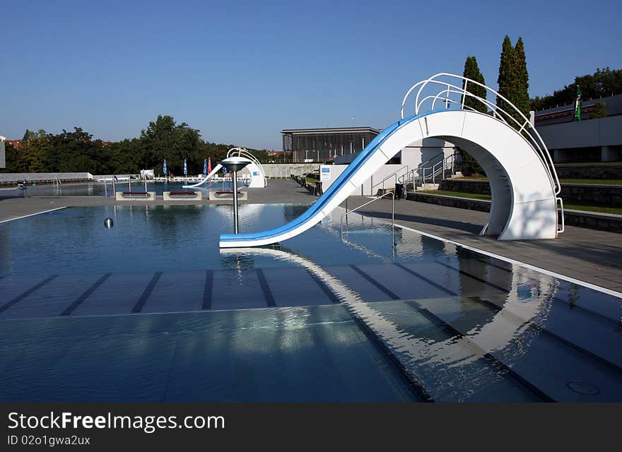 Dispeopled bath pool with white slide