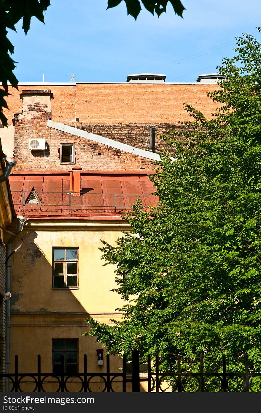 The part of wall with windows. Tree and blue sky. The part of wall with windows. Tree and blue sky.