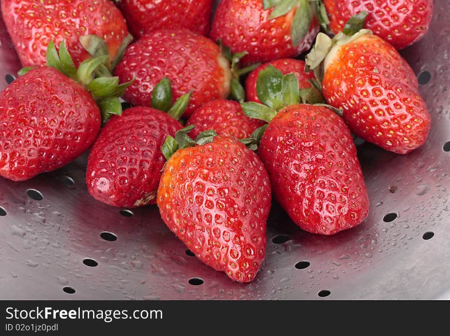 Fresh strawberries on steel colander