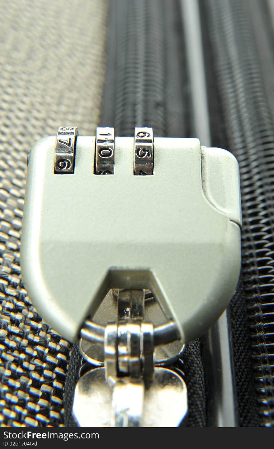 Padlock with figures in modern suitcase close-up