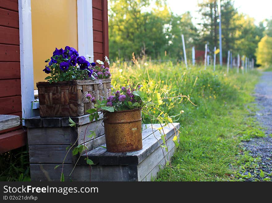 Pots and baskets with flowers outside old house. Pots and baskets with flowers outside old house