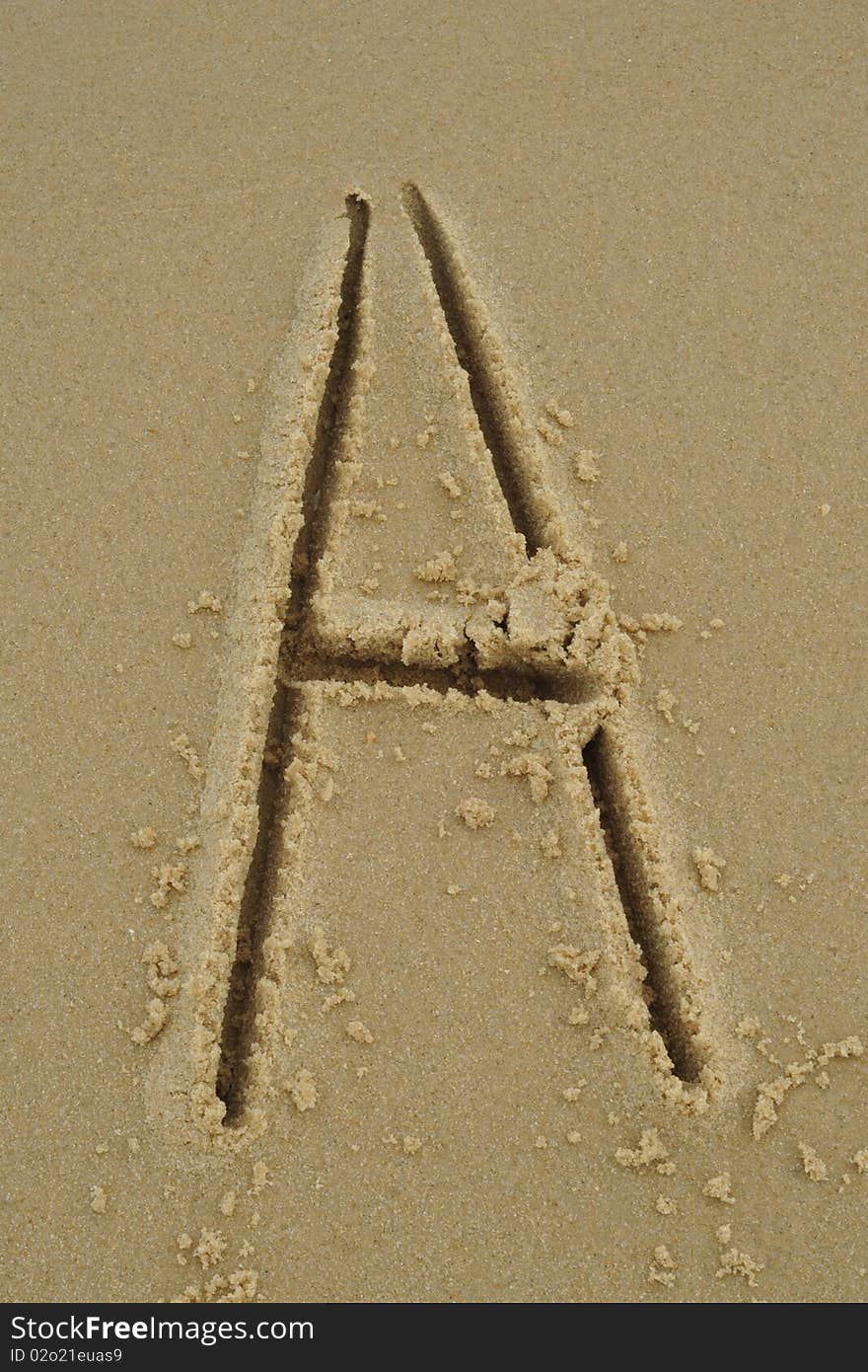 In the sand beach writes letter A