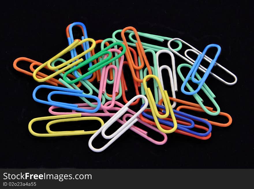 Pile of Colored Paperclips on Black background