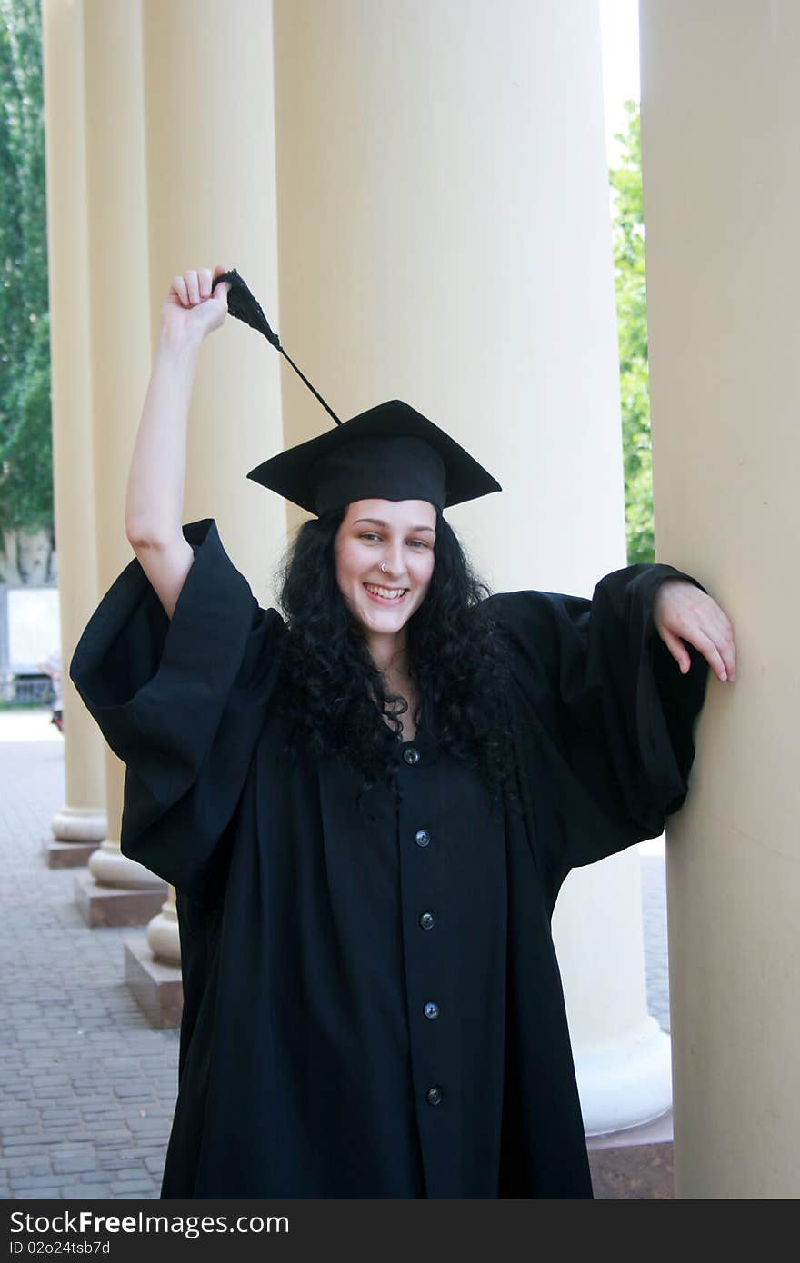 Young student in gown near the university. Young student in gown near the university