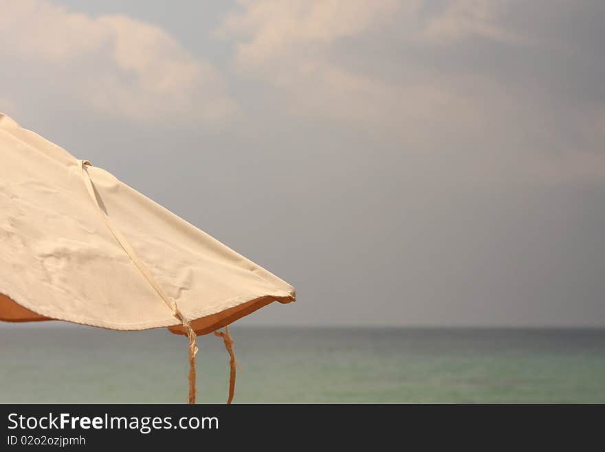 Fragment of a fabric beach umbrella  against sea and sky open space. Fragment of a fabric beach umbrella  against sea and sky open space.