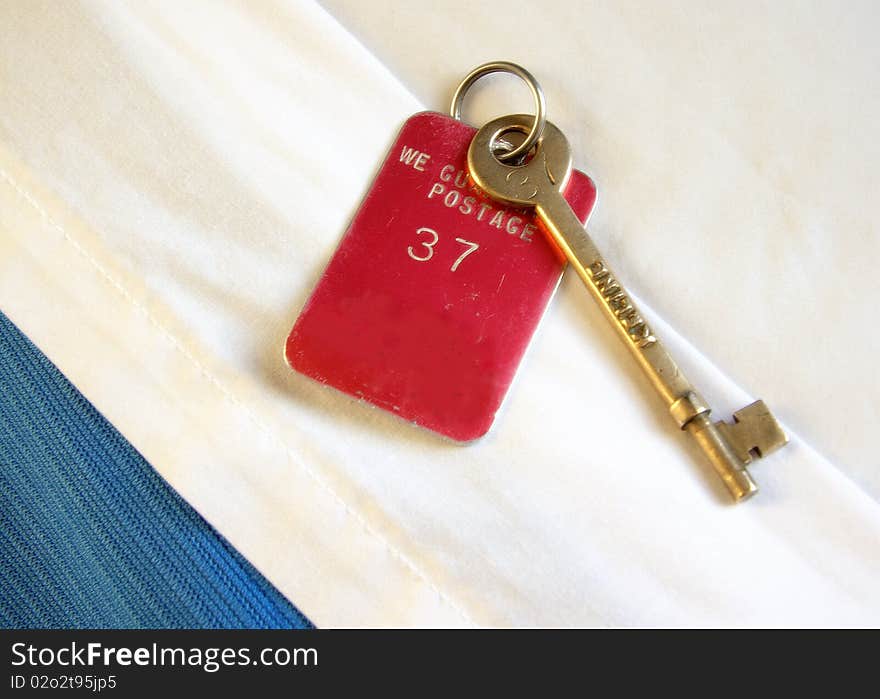 A ships stateroom key resting on the room's turned down sheets of the bed.