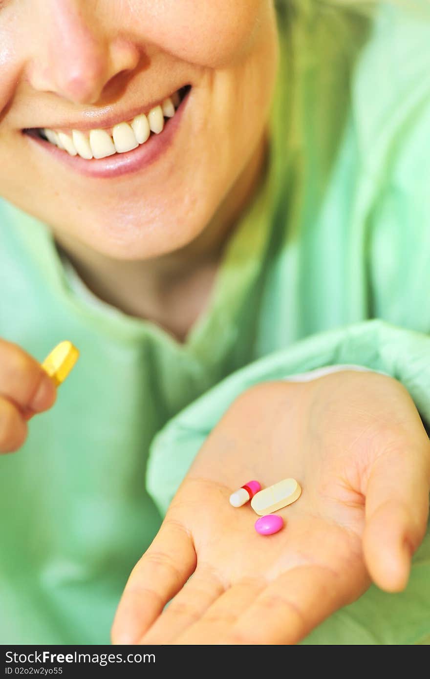 Woman holds pills in a hand inside of hospital