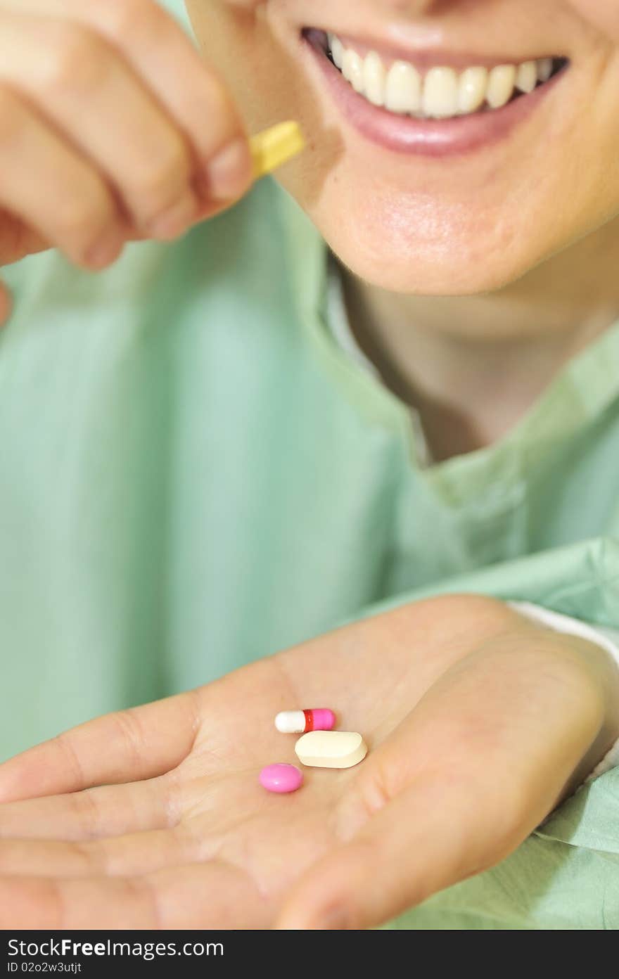 Woman holds pills in a hand inside of hospital