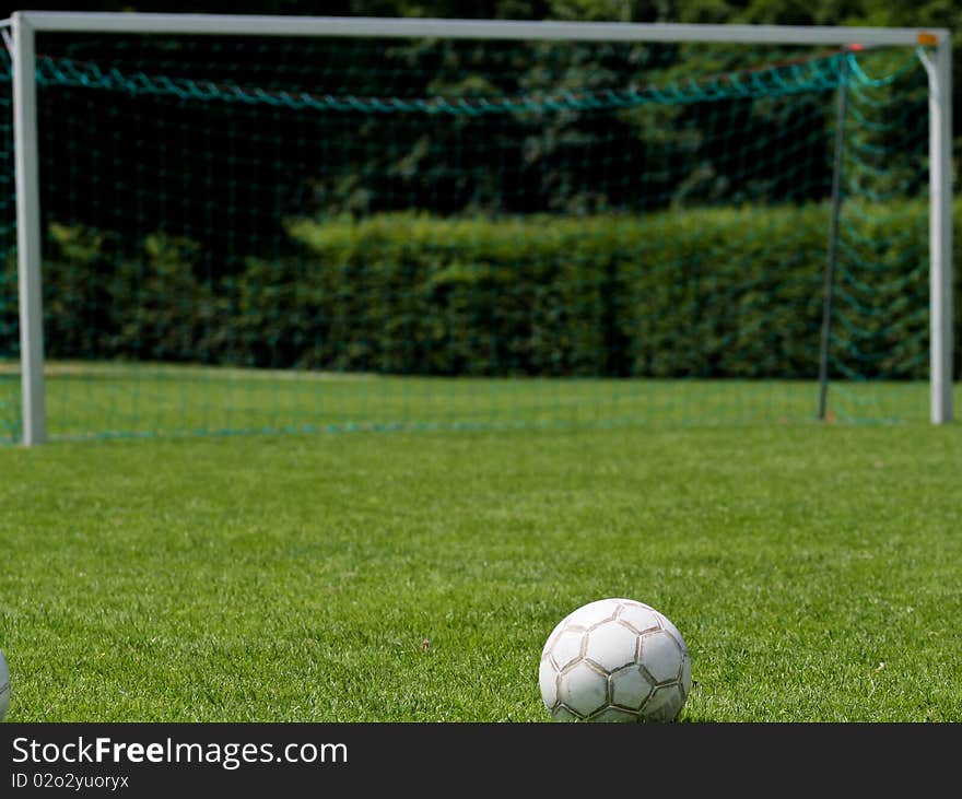 Soccer ball in front of goal on soccer field