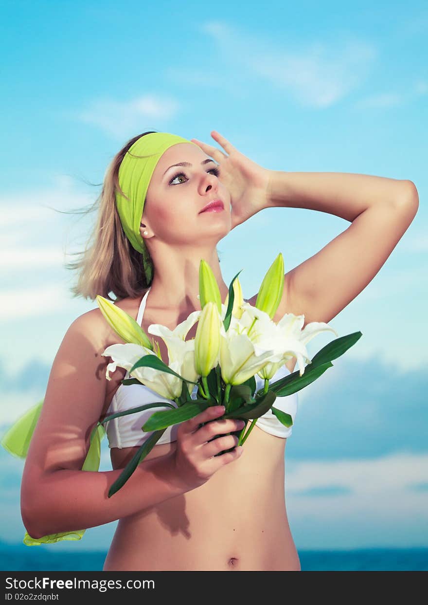 Beautiful woman near the ocean with flowers. Beautiful woman near the ocean with flowers