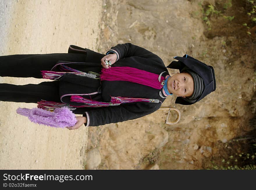 This woman is wearing the typical costume of the Dao ethnic black Tien. The trousers and black jacket. The burgundy jabot and cuff typical black cord wrapped surmounted by a truncated inverted pyramid, which is covered with a black cloth. Most women have retained the traditional dress while men are often dressed in modern clothes. This woman is wearing the typical costume of the Dao ethnic black Tien. The trousers and black jacket. The burgundy jabot and cuff typical black cord wrapped surmounted by a truncated inverted pyramid, which is covered with a black cloth. Most women have retained the traditional dress while men are often dressed in modern clothes.
