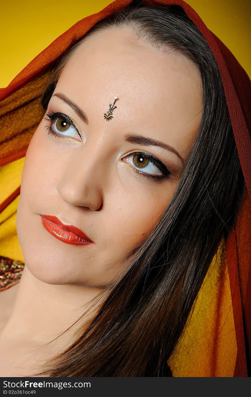 Young beautiful woman in indian traditional style. yellow background