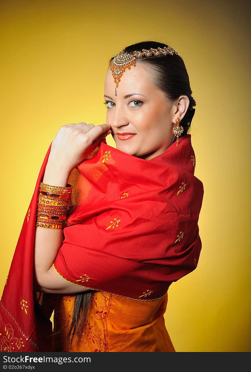 Young beautiful woman in indian traditional style. yellow background