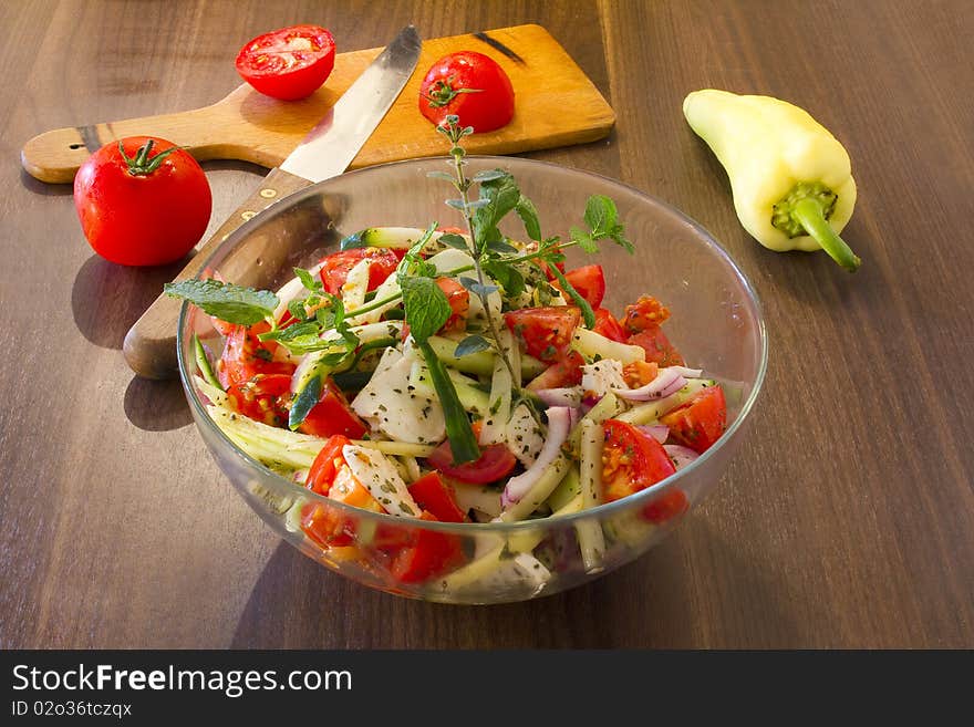 Salad of tomato, pepper, cucumber and purple onion, in olive oil, with menta and oregano sprig. Salad of tomato, pepper, cucumber and purple onion, in olive oil, with menta and oregano sprig.