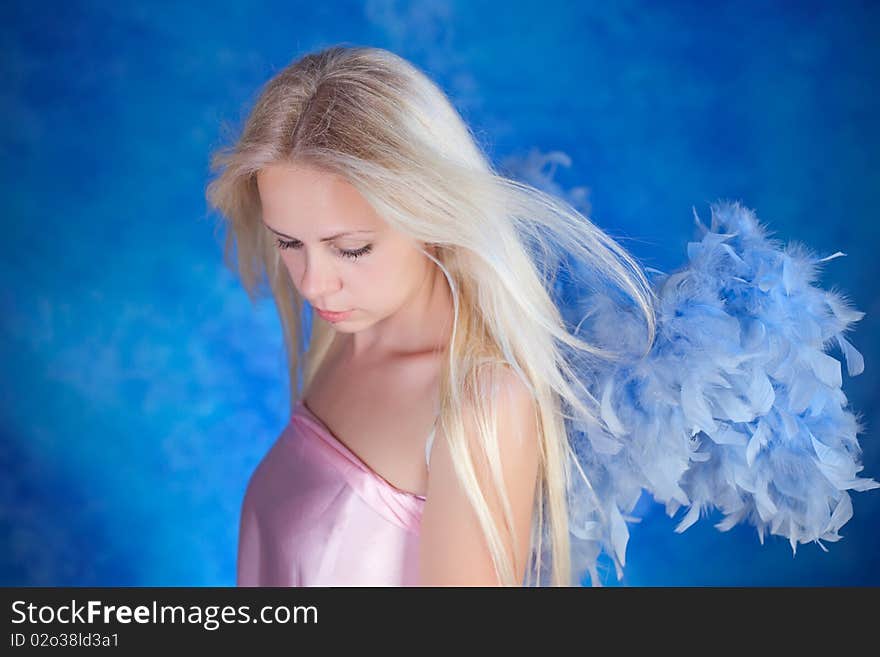 Beautiful girl posing on a blue background. Beautiful girl posing on a blue background