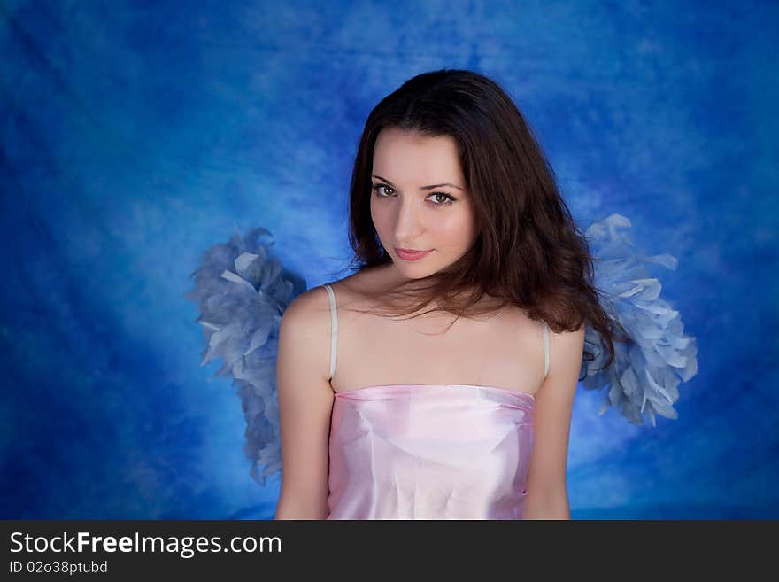 Beautiful girl posing on a blue background. Beautiful girl posing on a blue background