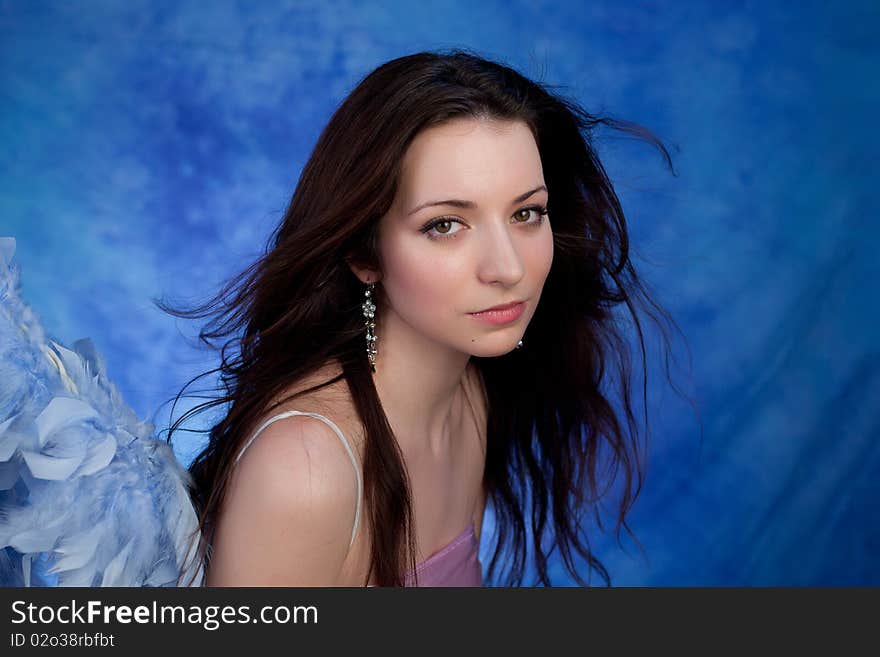 Beautiful girl posing on a blue background. Beautiful girl posing on a blue background