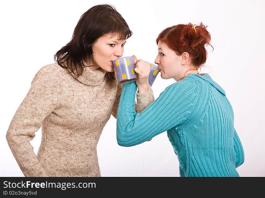 Two young beautiful girls drink coffee. Two young beautiful girls drink coffee