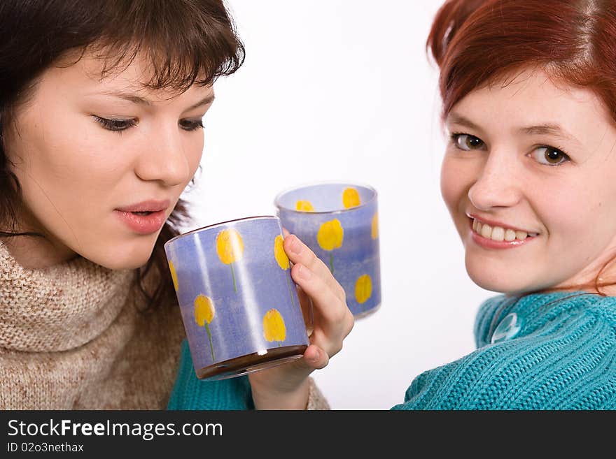 Two young beautiful girls drink coffee. Two young beautiful girls drink coffee