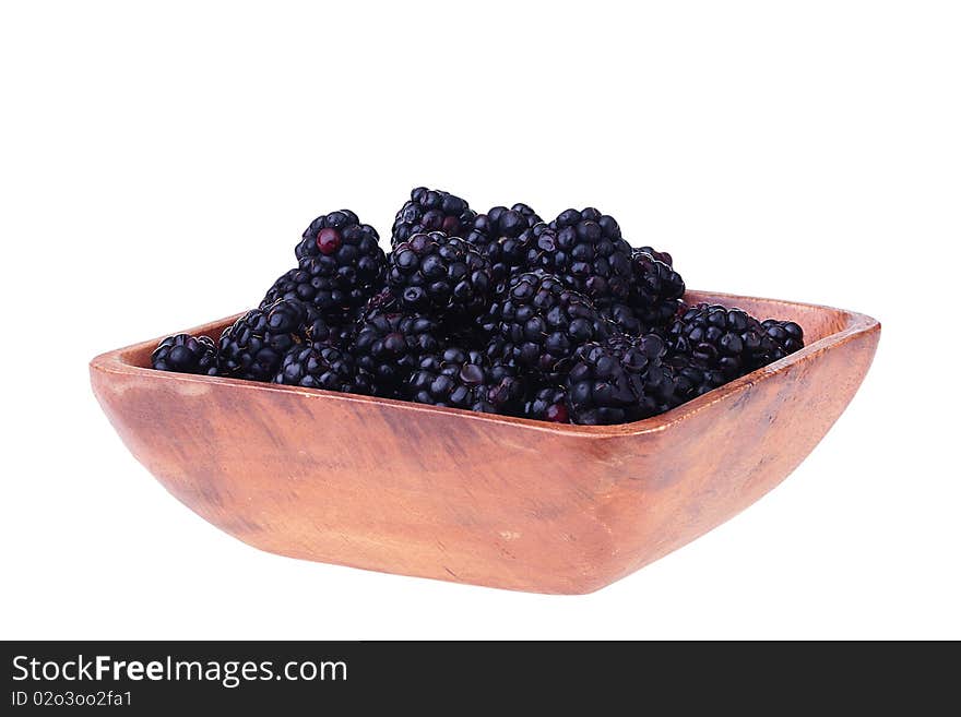 Blackberry - berries of black colour in a wooden plate on a white background. Blackberry - berries of black colour in a wooden plate on a white background.