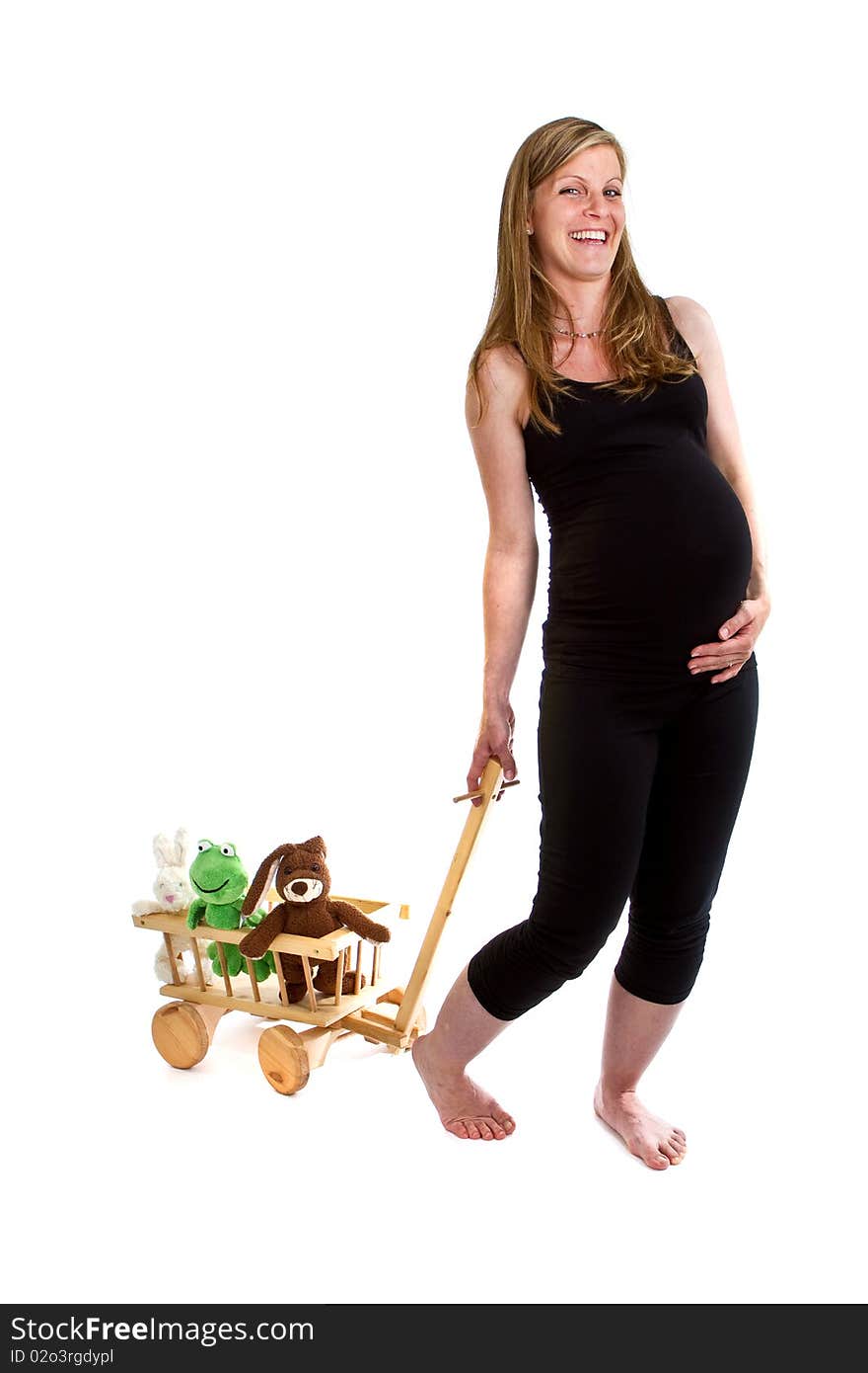 Young fresh pregnant woman is pulling a trolley filled with toy animals isolated over white background. Young fresh pregnant woman is pulling a trolley filled with toy animals isolated over white background.