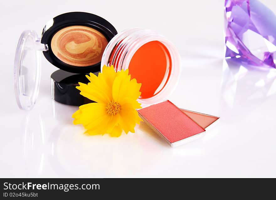 Cosmetics with a yellow flower and violet crystal