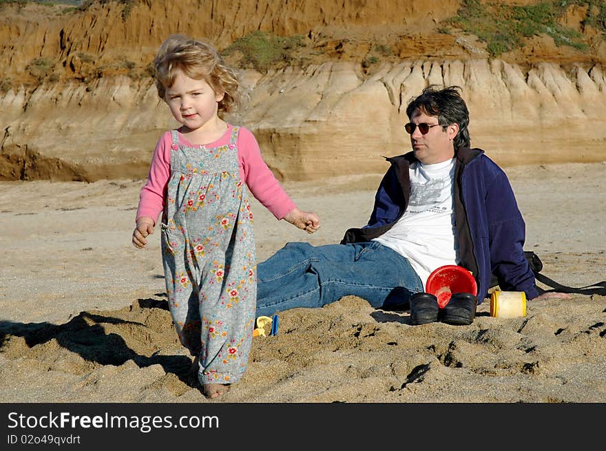 Two year old girl with father on beach. Two year old girl with father on beach