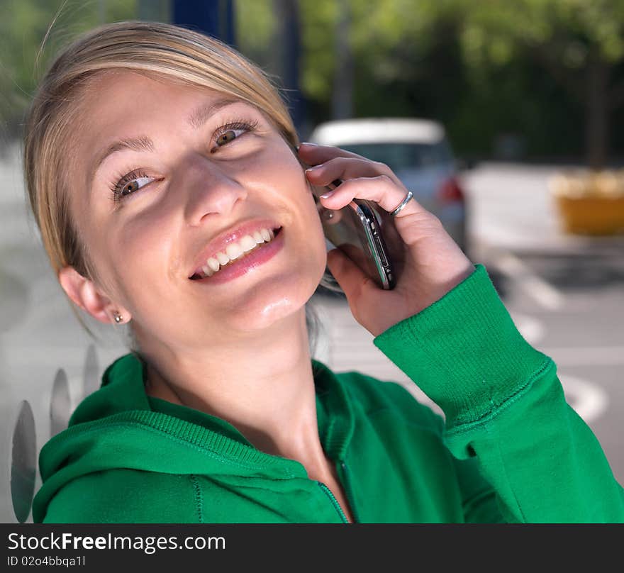 An attractive, confident blond woman makes a call on her mobile phone ,she is smiling and happy in a relaxed attitude. An attractive, confident blond woman makes a call on her mobile phone ,she is smiling and happy in a relaxed attitude.