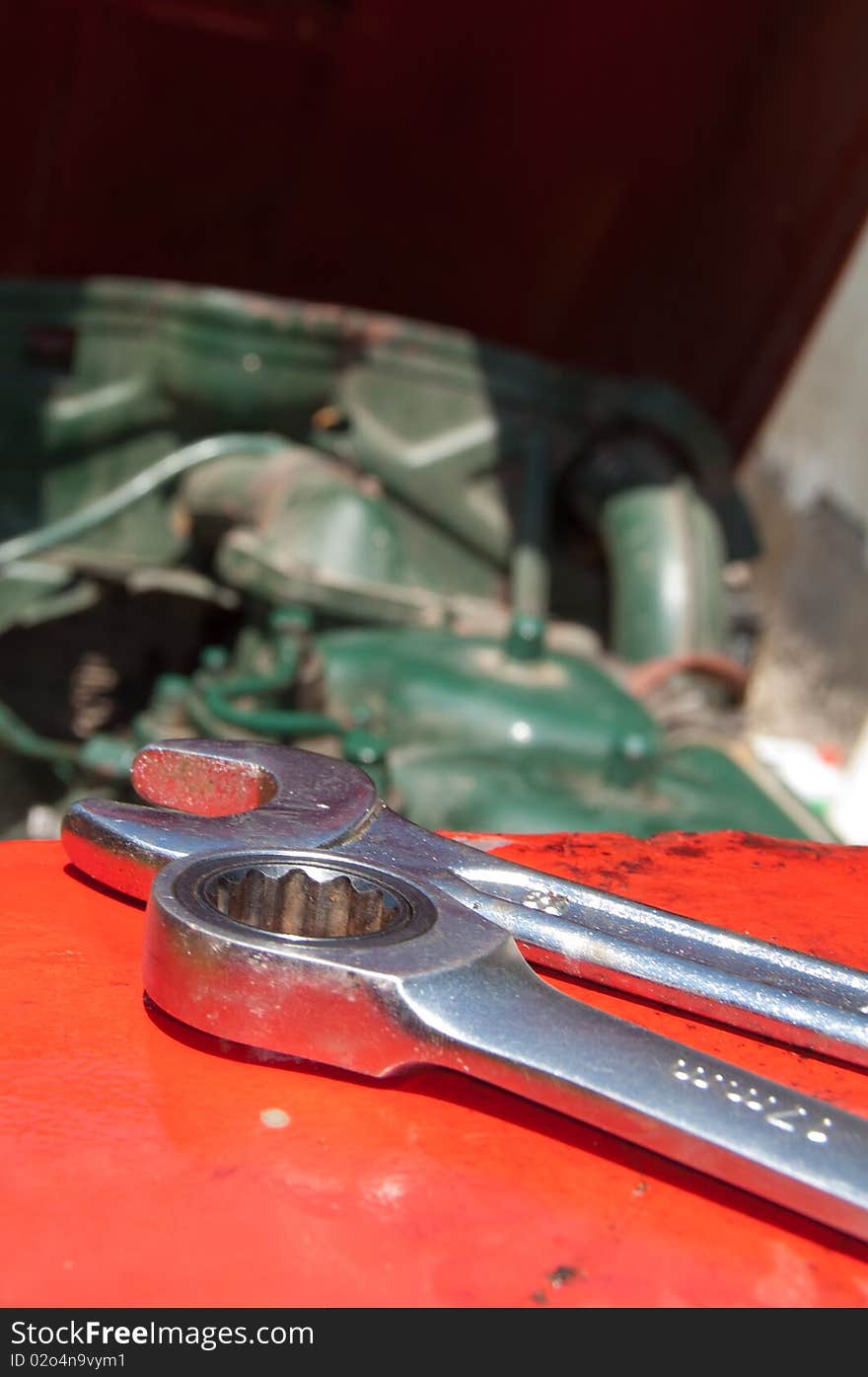 Detail of metal wrenches on old-timer tractor with part of engine. Detail of metal wrenches on old-timer tractor with part of engine