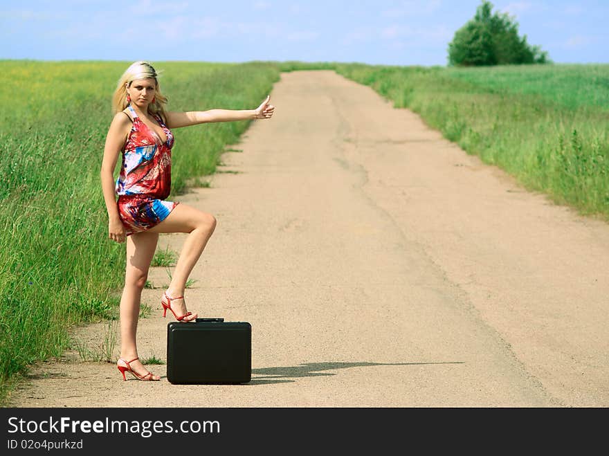 young hitchhiker woman on the road. Outdoor shooting. young hitchhiker woman on the road. Outdoor shooting.