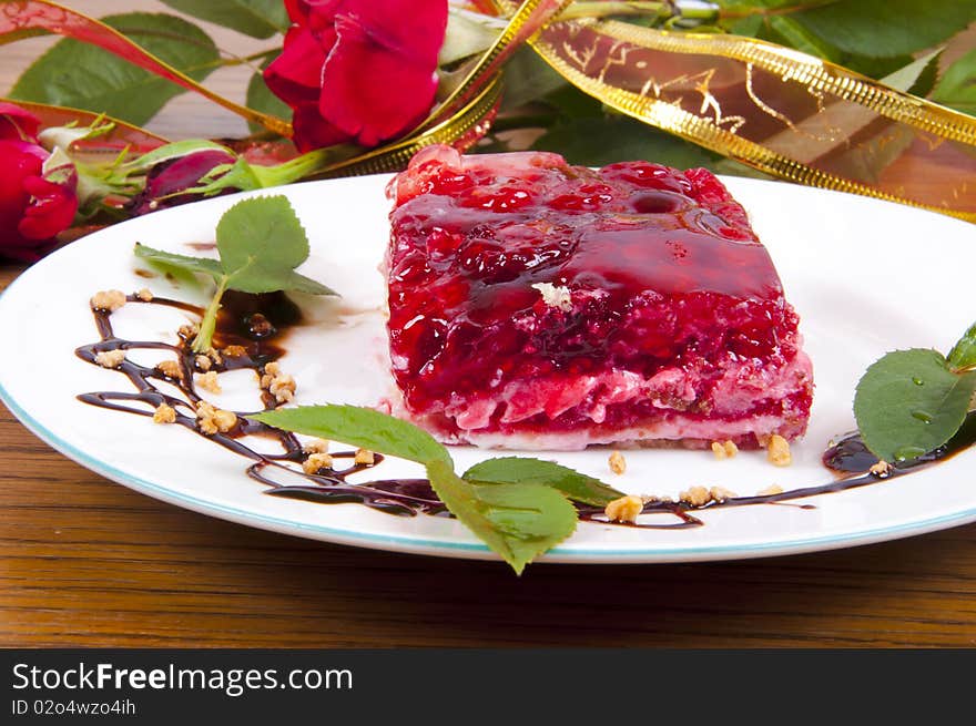 Sweet raspberry and strawberries dessert with chocolate on white plate