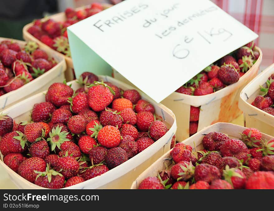 The last strawberries sold in cases on a village market in France. The last strawberries sold in cases on a village market in France