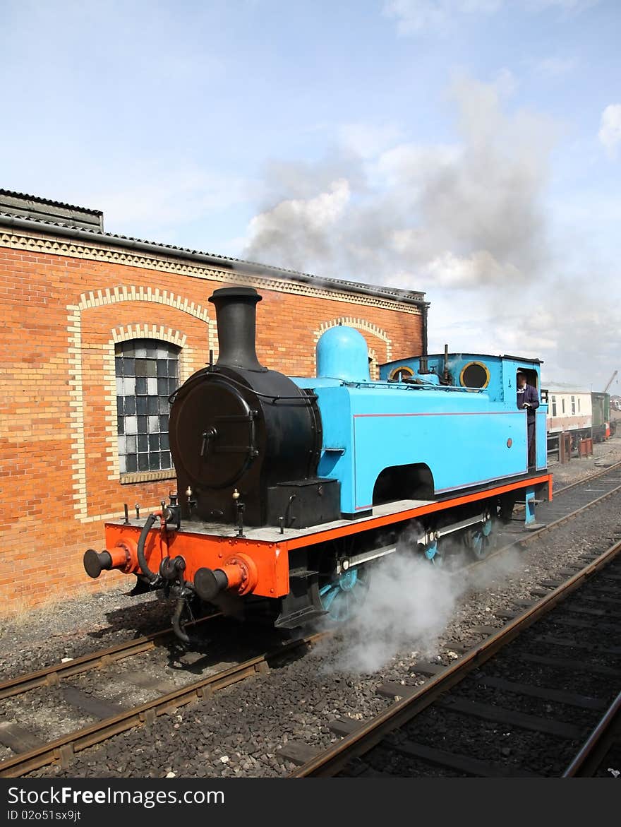 Stream train in yard afterbtacking on coal with steam venting from the loco. Stream train in yard afterbtacking on coal with steam venting from the loco