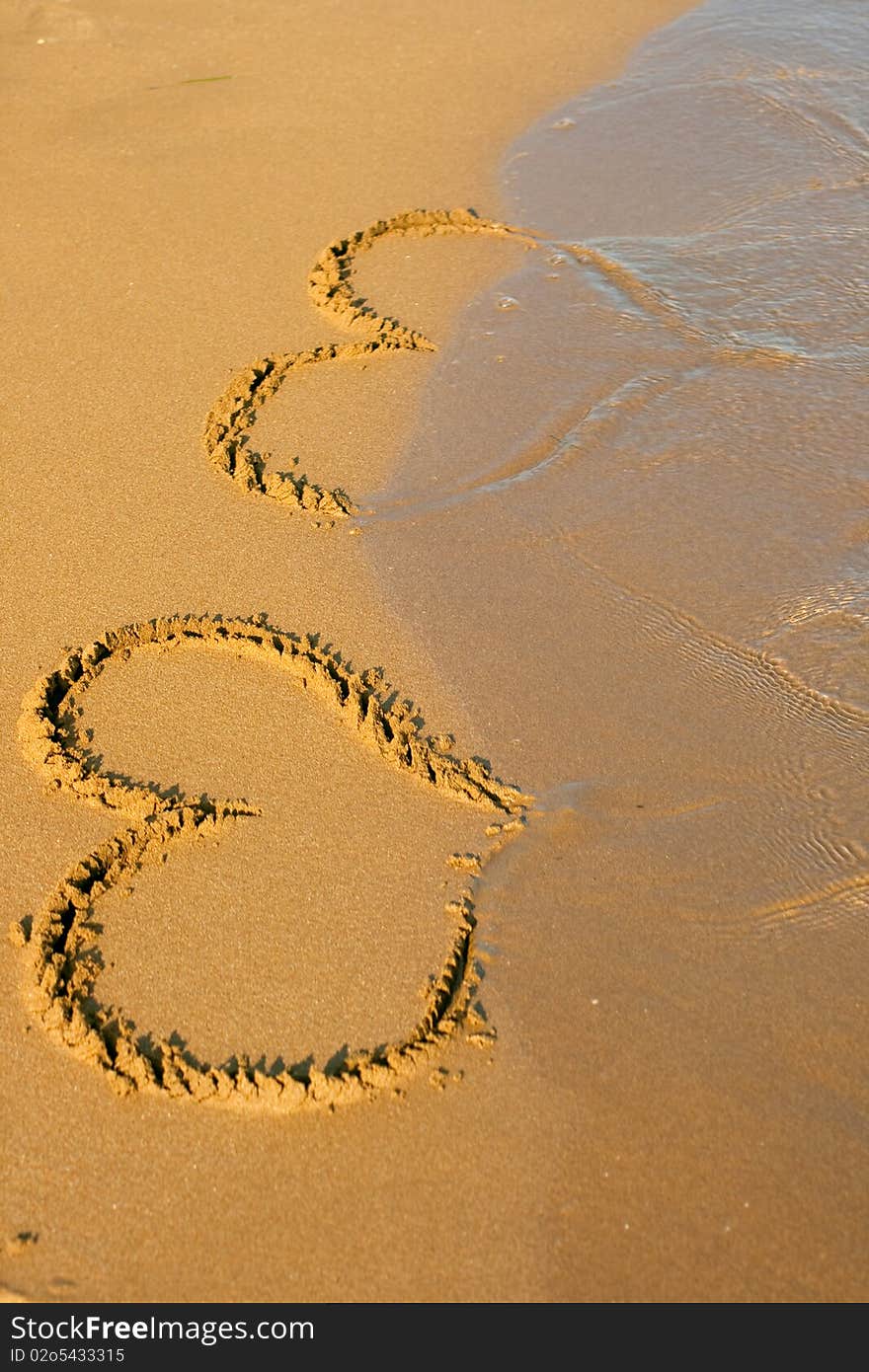 Hearts drawing in the sand on the beach