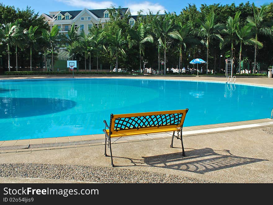 Bench beside a swimming pool.