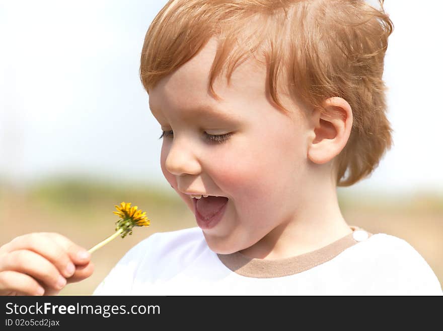 Happy boy enjoy with yellow dandelion