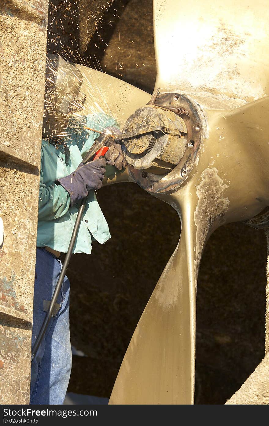 Arc welder arcing a strap off of a tug boat wheel. Arc welder arcing a strap off of a tug boat wheel