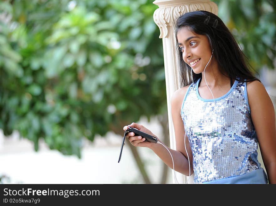 Beautiful young girl listening music outdoors. Beautiful young girl listening music outdoors