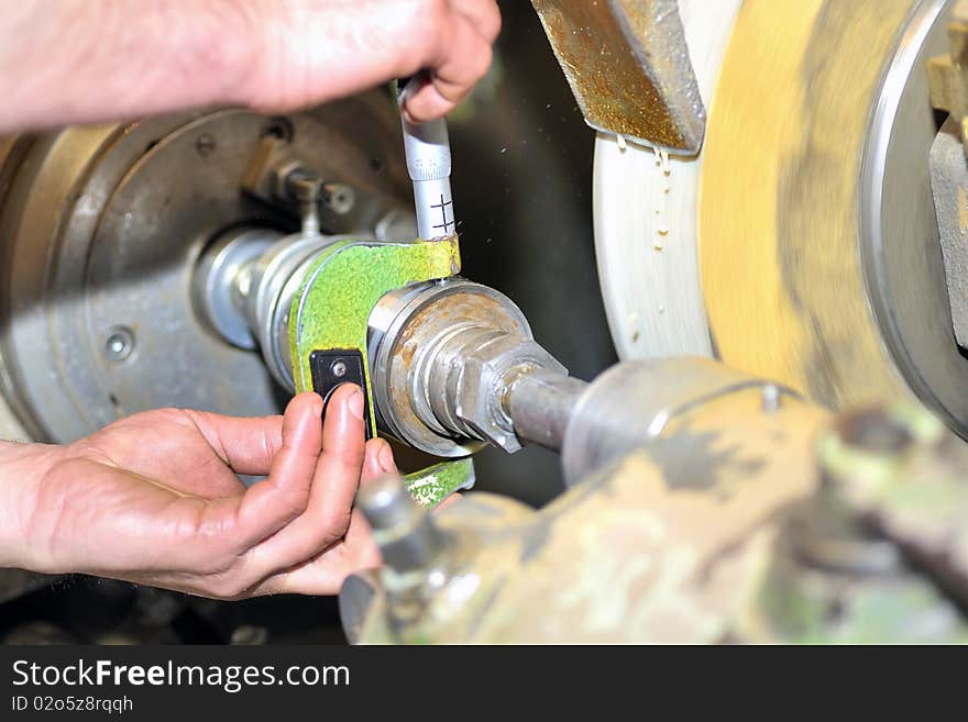 Close up of measuring metal part on lathe