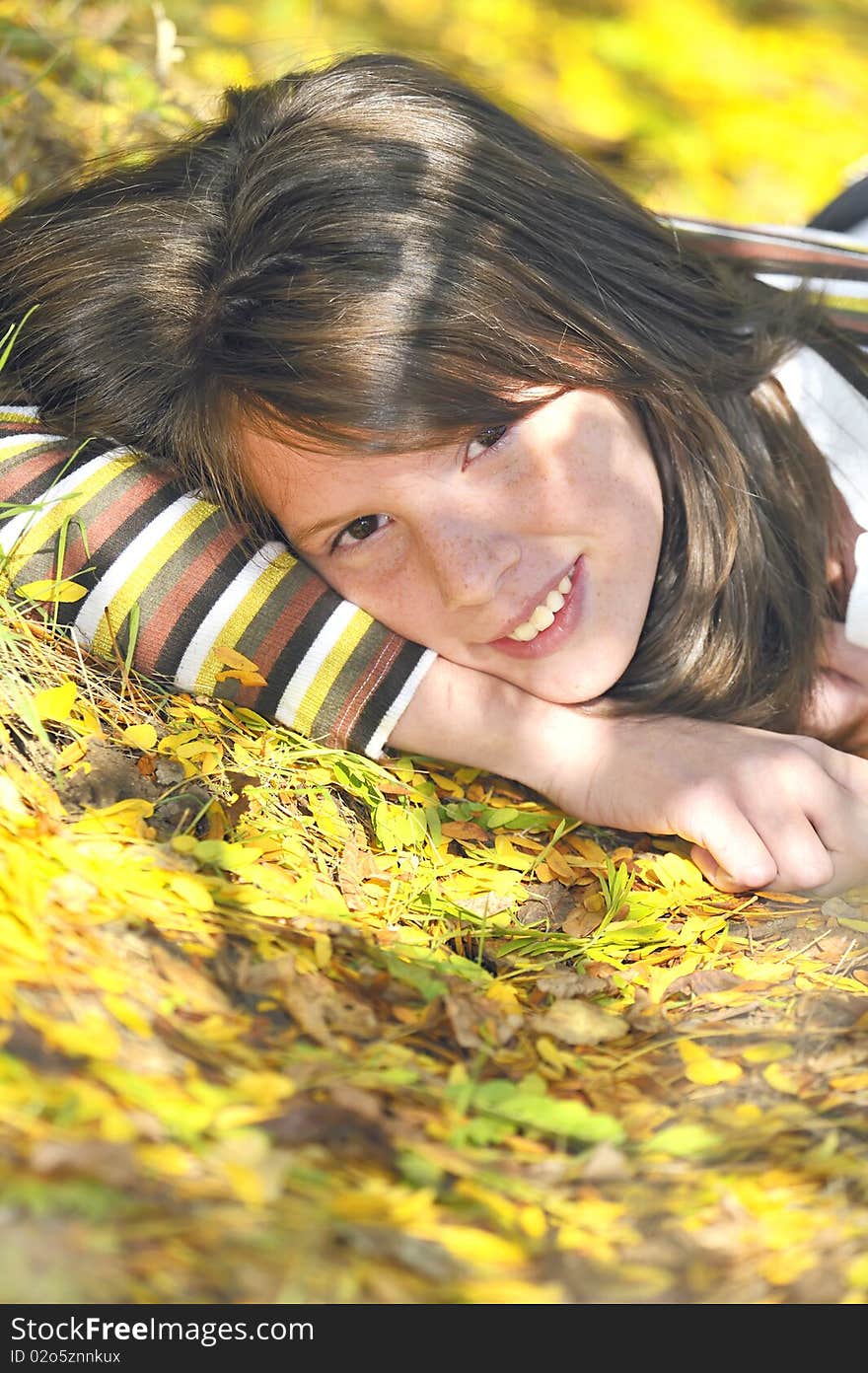 Portrait of a smiling girl lying on leaves