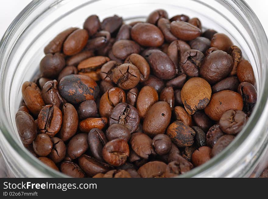 Coffee beans inside glass jar on white background. Coffee beans inside glass jar on white background