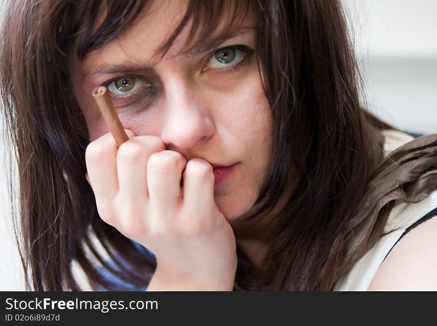 Upset young woman with a bruised eye and cigar. Upset young woman with a bruised eye and cigar