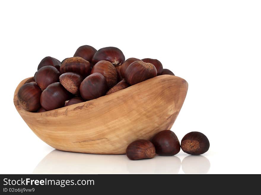 Chestnut collection in an olive wood bowl and scattered, isolated over white background with reflection. Castanea. Chestnut collection in an olive wood bowl and scattered, isolated over white background with reflection. Castanea.