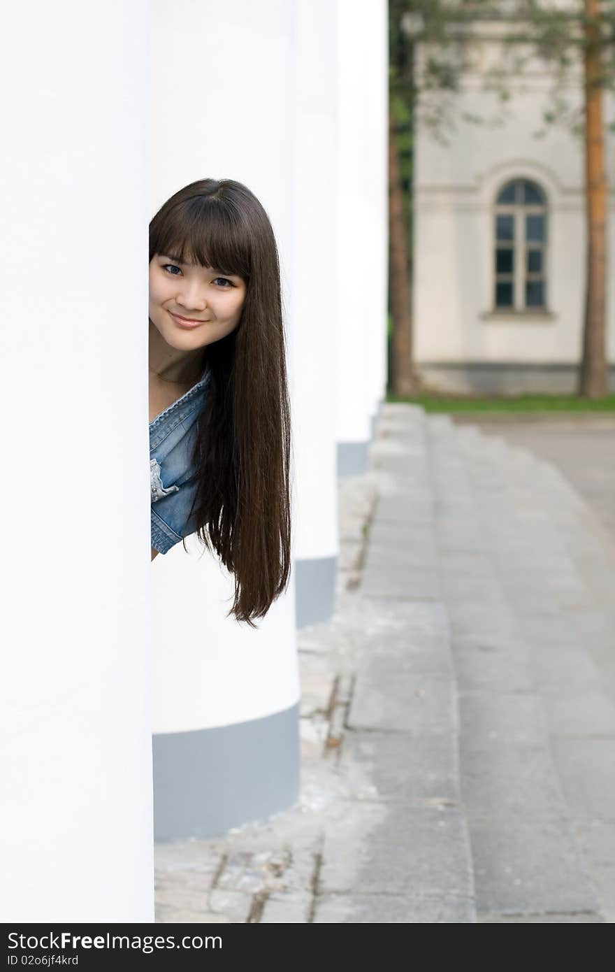 Girl hiding behind column outdoor